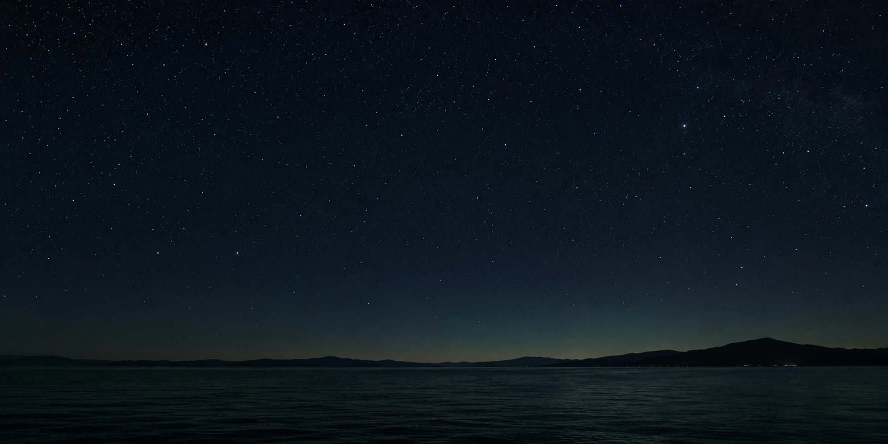 Ciel nocturne étoilé au-dessus d’un horizon marin dégagé